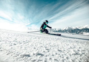 Junge fährt mit Vollgas eine Schneepiste runter.